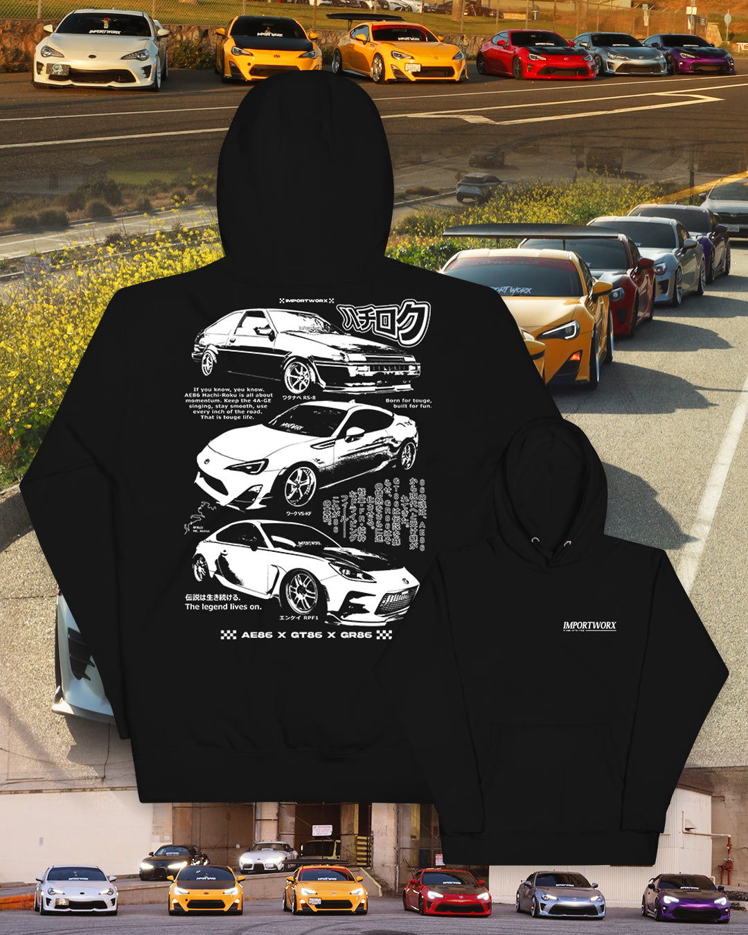 Black hoodie with car graphics and text, displayed in front of a row of cars on a road.