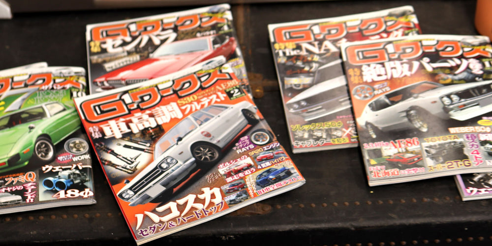 Collection of car magazines on a dark surface