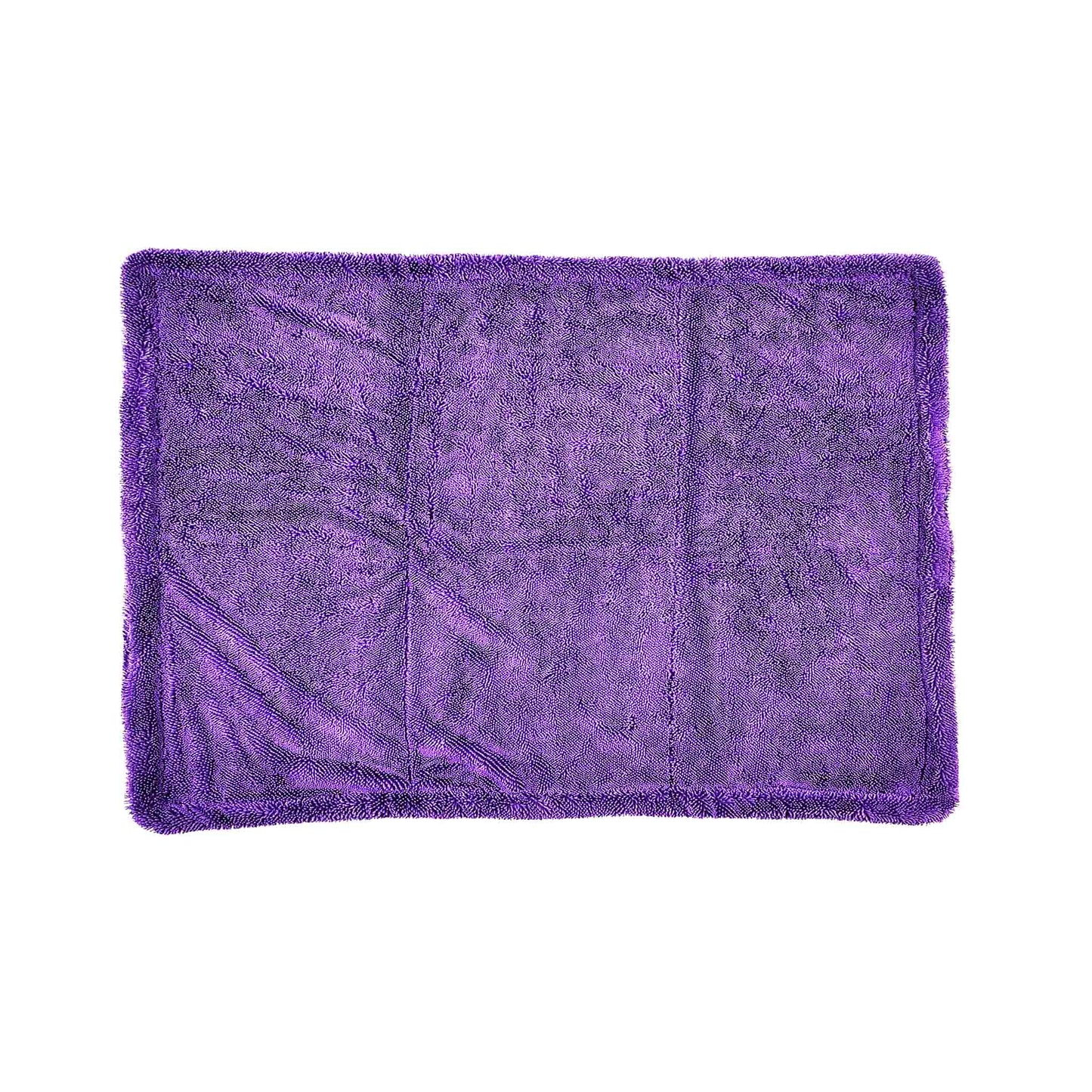 A rectangular purple plush microfiber towel with a shaggy texture and fringed edges, laid flat against a solid white background.