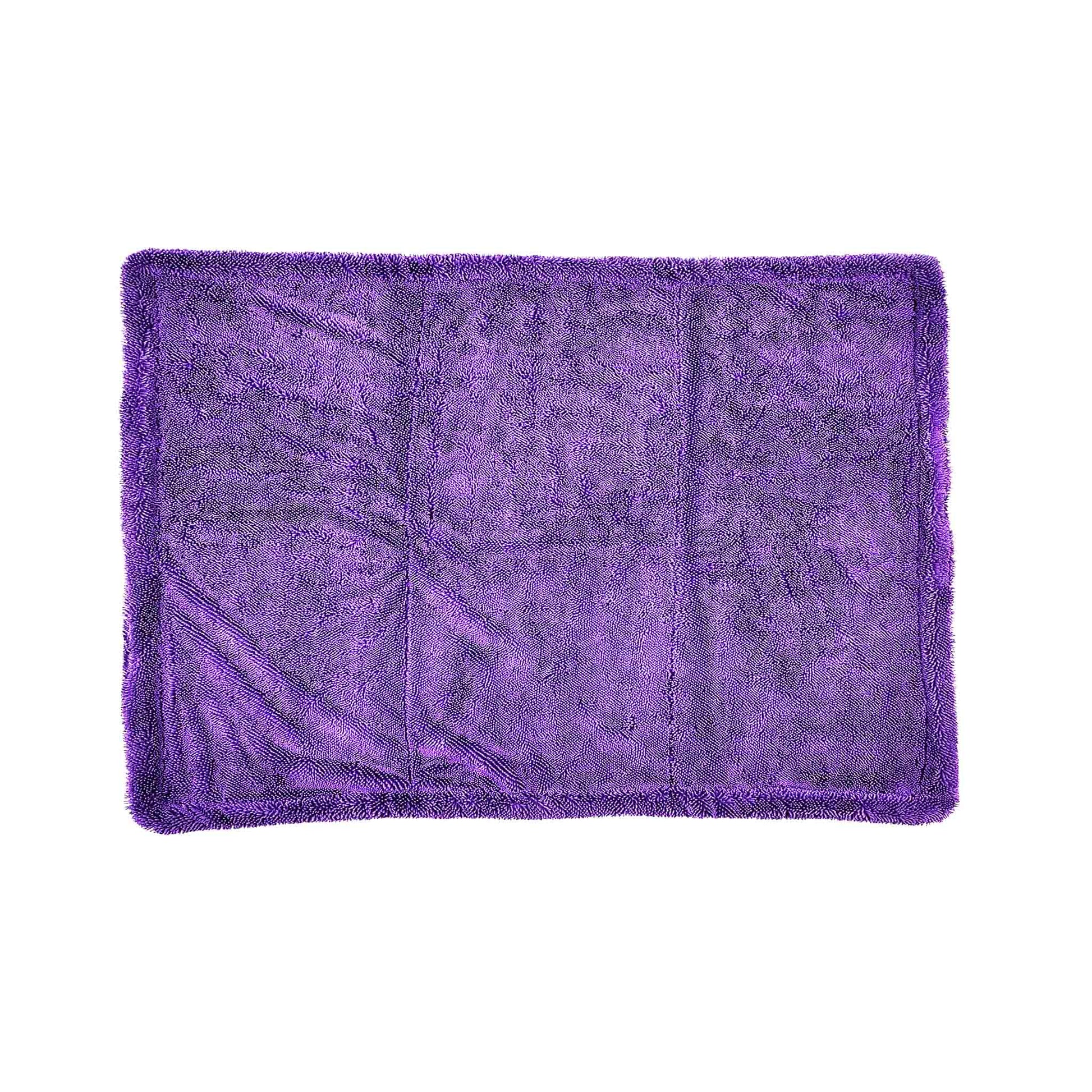 A rectangular purple plush microfiber towel with a shaggy texture and fringed edges, laid flat against a solid white background.