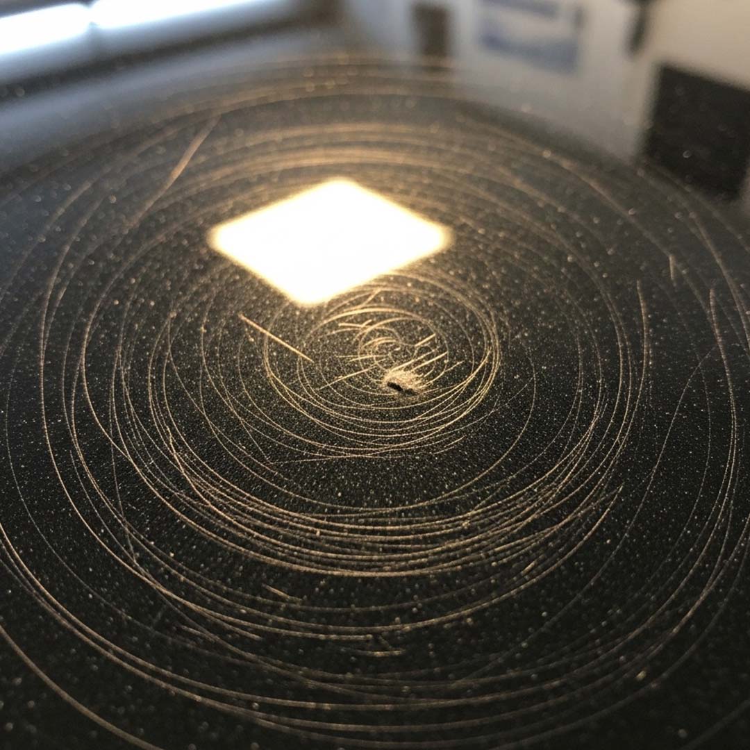Black car hood with swirl marks and scratches