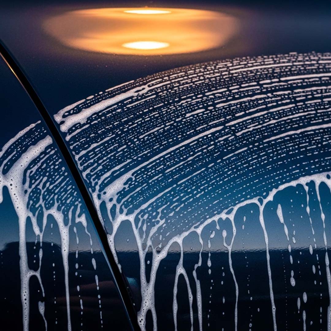 Foamy car wash with sunset reflection on water surface
